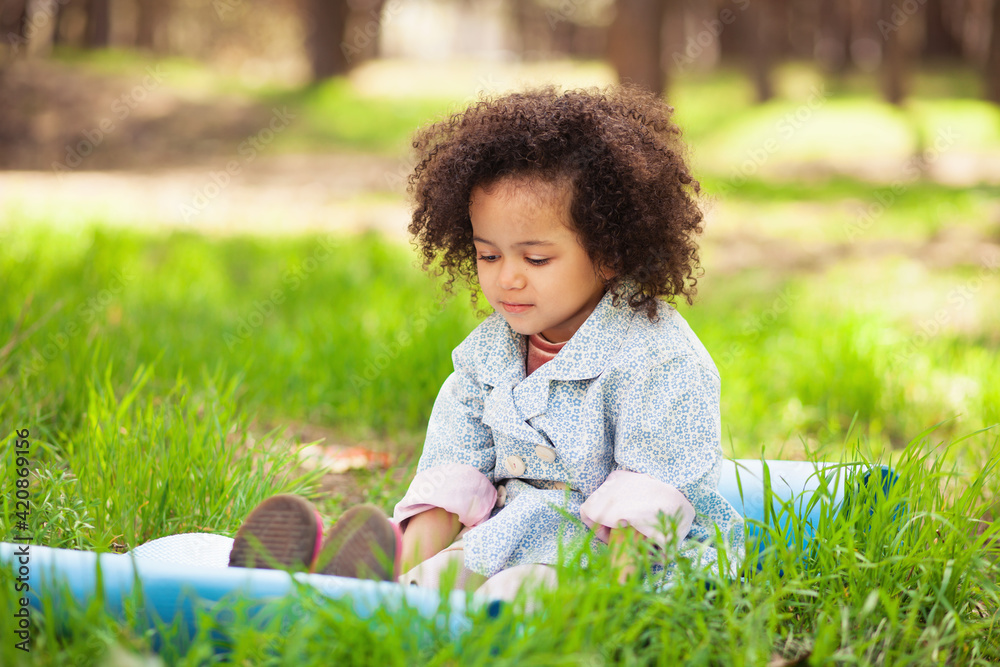 Cute little girl sitting on the grass Cute little girl sitting on the grass