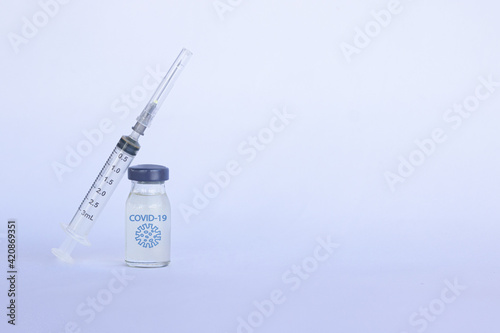 Coronavirus vaccine with a syringe on white background. Copy space photo