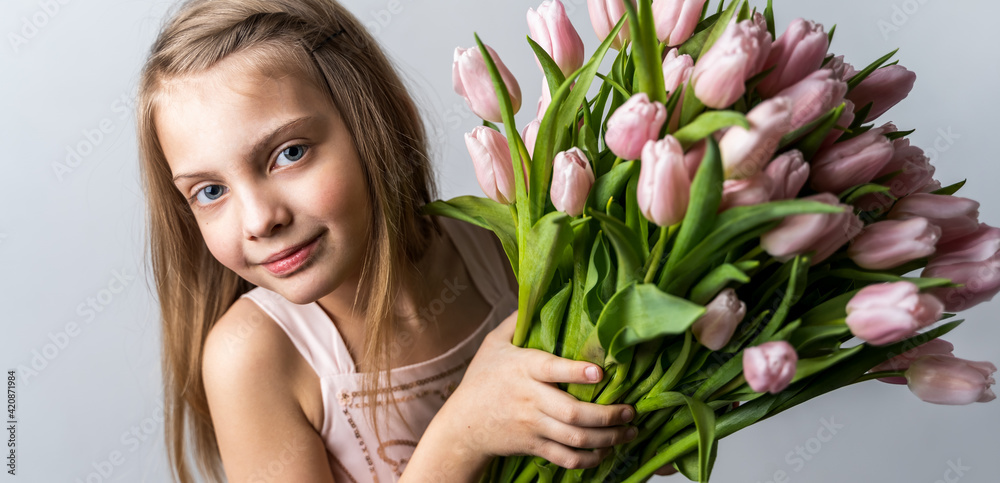 Banner with little beautiful girl holding bunch of pink tulips in hands. Bouquet, congratulations to the holiday of mother, valentine's. International Women's Day, 8 March.Spring,summer time concept Banner with little beautiful girl holding bunch of pink tulips in hands. Bouquet, congratulations to the holiday of mother, valentine's. International Women's Day, 8 March.Spring,summer time concept