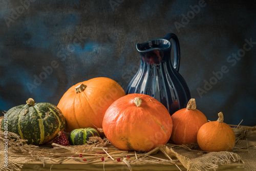 Pumpkins, pomegranate seeds and a blue jug.