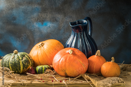 pumpkins, pomegranate seeds and a blue jug on the table 