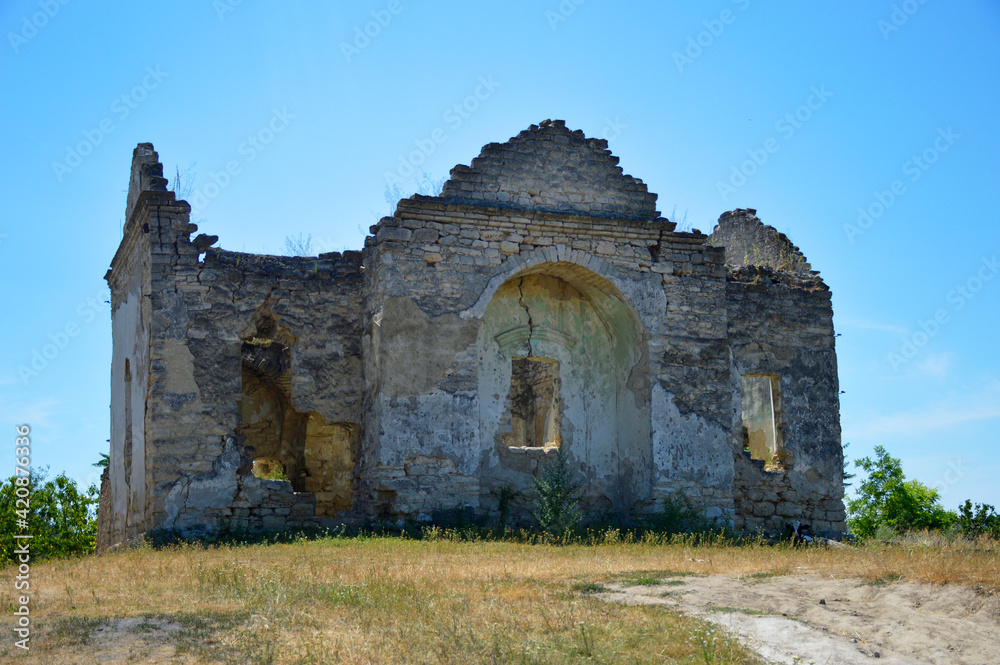 ancient ruins of an Orthodox church, cracked and destroyed walls, empty window openings, bushes grow inside the building