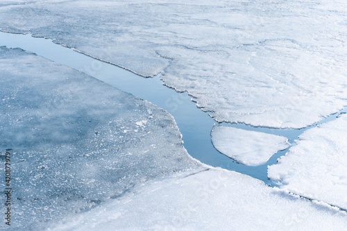 An ice floe breaks ups in the spring thaw revealing the frigid water below.