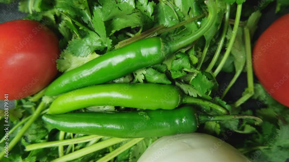 Chili peppers, onion, and a tomatoes above coriander Chili peppers, onion, and a tomatoes above coriander