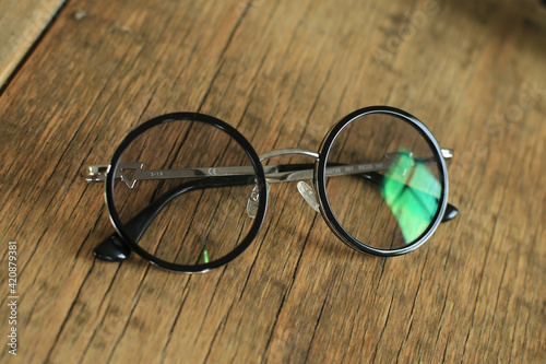 Round black-rimmed glasses on a wooden table