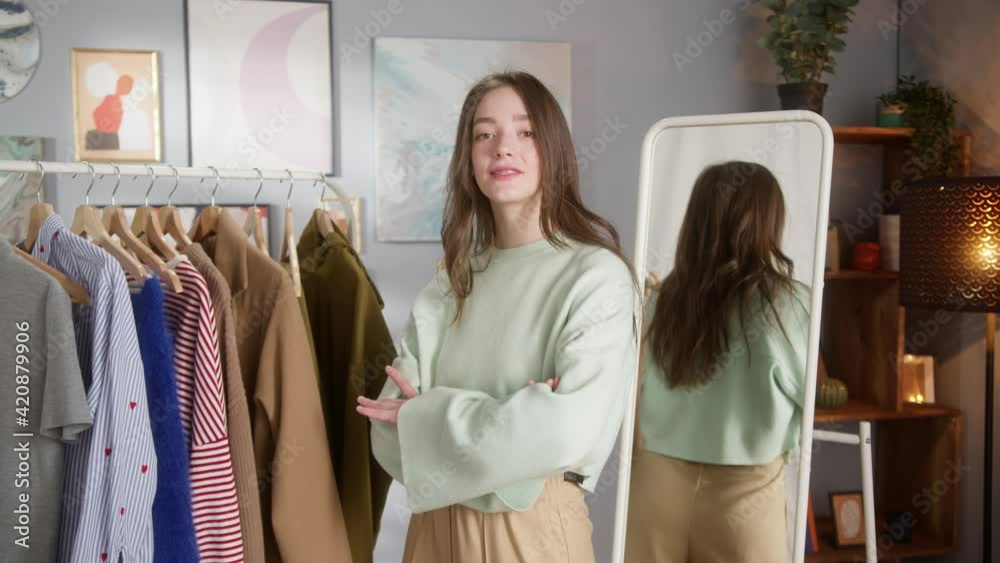 Small business owner wearing cute sweatshirt in clothes concept store, stylist shopping assistance, woman blogger choosing clothes in wardrobe, crossing hands and smiling. Work after covid lockdown. Small business owner wearing cute sweatshirt in clothes concept store, stylist shopping assistance, woman blogger choosing clothes in wardrobe, crossing hands and smiling. Work after covid lockdown.
