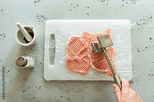 Fotografie Cooking - chef tenderizing meat slice with mallet