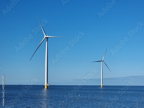 Windmill village indrustial wind mill by the lake Ijsselmeer Nehterlands. renewable energy green energy photo