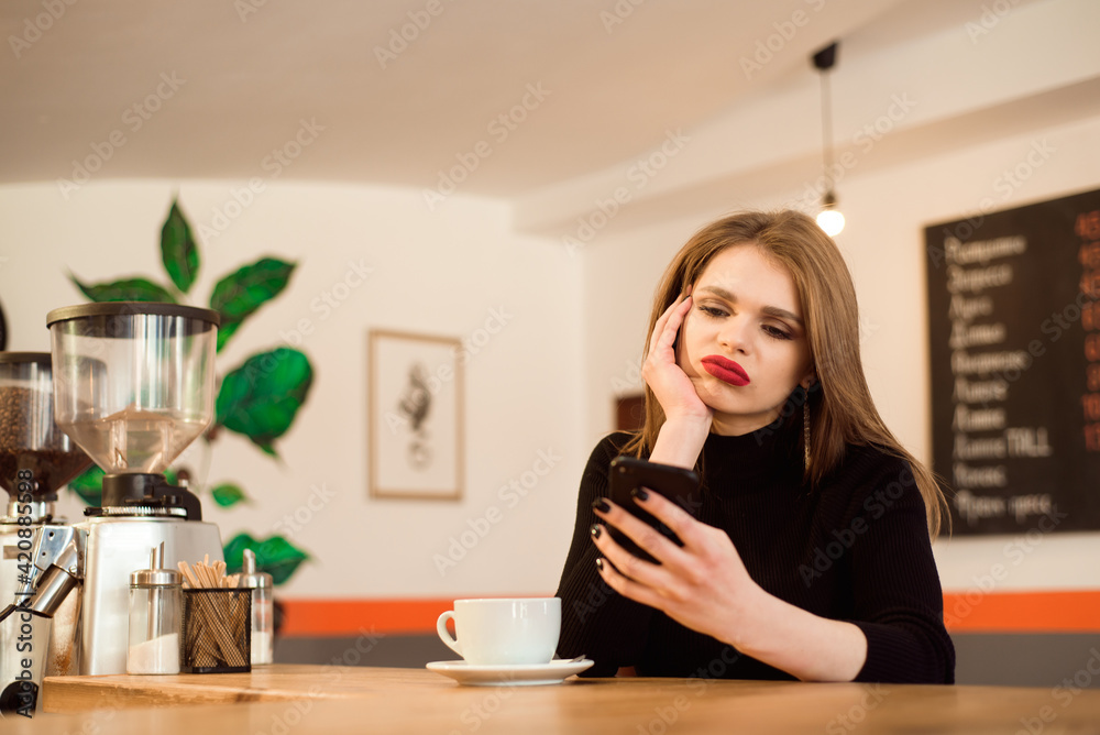 happy Caucasian female watching her photo on cell telephone while relaxing in cafe. happy Caucasian female watching her photo on cell telephone while relaxing in cafe.