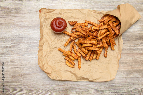 Fried fries in a bag. The potatoes are sprinkled on parchment paper.