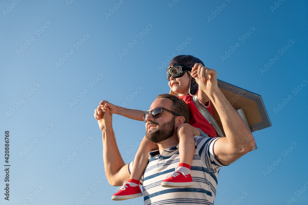Father and son playing against blue summer sky background Father and son playing against blue summer sky background