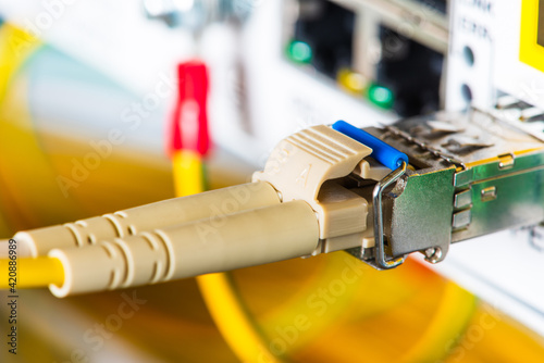 Fiber optic patch cord with gbic connected to switch in data center, close-up view photo