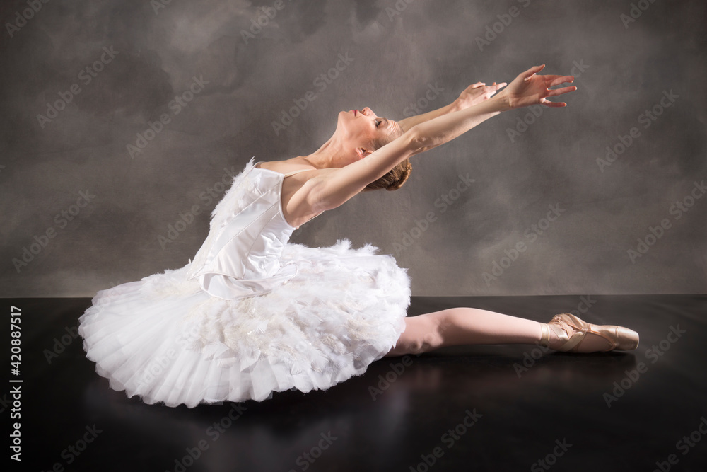 Naklejka premium Ballerina in white tutu, leaning back like a swan.