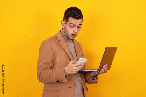 young man with smartphone and laptop isolated on background