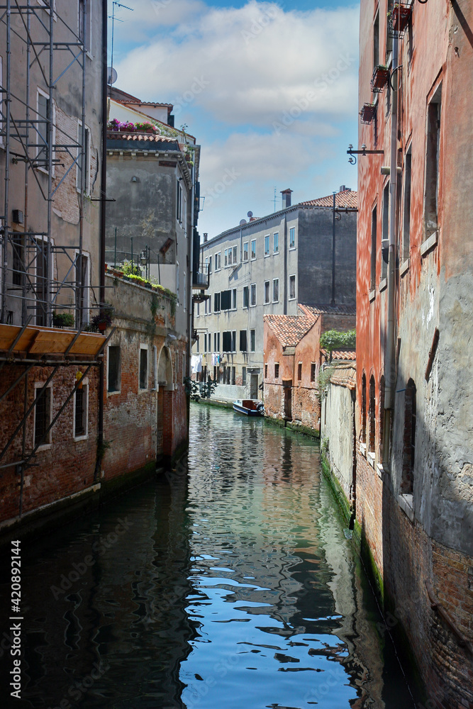 Narrow canal in Venice, Italy with colourful buildings around . cloudy day
