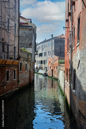 Narrow canal in Venice, Italy with colourful buildings around . cloudy day
