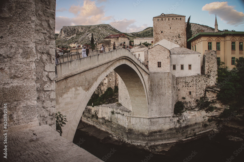 Famous concete or stone bridge in Mostar, Bosnia on a warm summer day. Famous concete or stone bridge in Mostar, Bosnia on a warm summer day.
