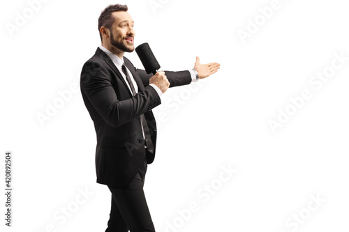Fotografi Male tv show host with a microphone gesturing with hand