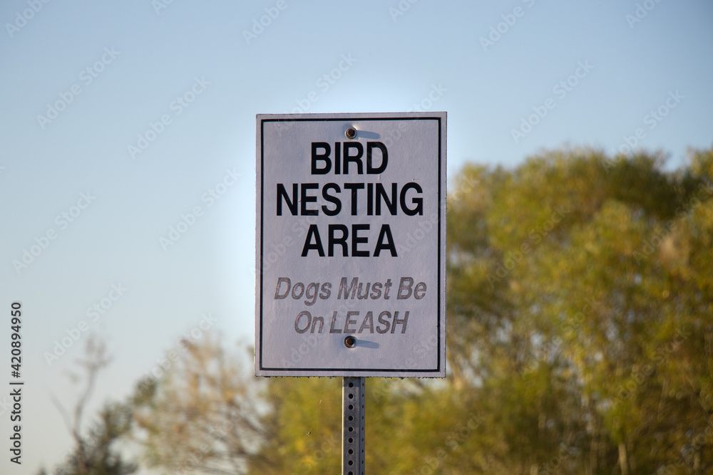 View of sign Bird Nesting Area, Dogs Must be on Leash in Courtenay, Canada