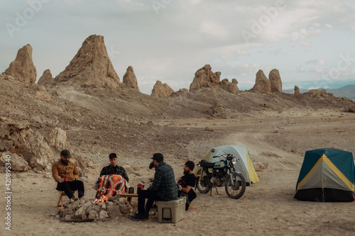 Motorcyclist road trippers around camp fire, Trona Pinnacles, California, US photo