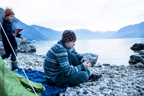 Father and son camping by lakeside, Onno, Lombardy, Italy