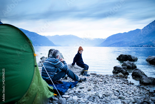 Father and son camping by lakeside, Onno, Lombardy, Italy