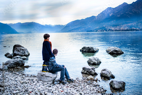 Father and son on lakeside, Onno, Lombardy, Italy