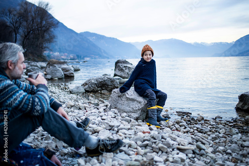 Father and son on lakeside, Onno, Lombardy, Italy