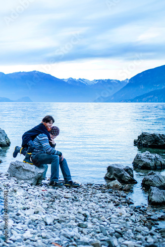 Father and son on lakeside, Onno, Lombardy, Italy