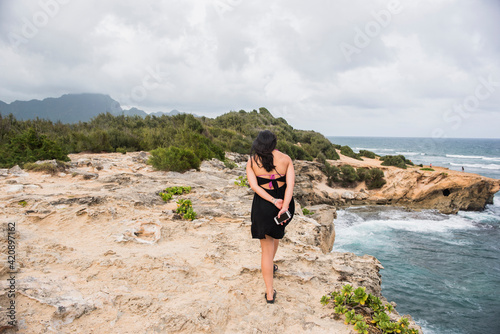 Woman walking with cellphone in hand, Shipwreck Beach, Kauai, Hawaii photo
