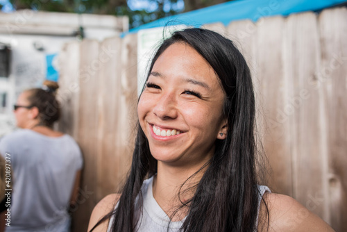 Smiling woman by wooden fence, Haleiwa, Oahu, Hawaii photo