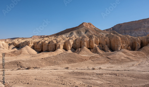 Multicolored mountain landscape in the Negev Desert. Bizarre forms of weathered sandstone in the mountains. Mountain folds of unusual form.