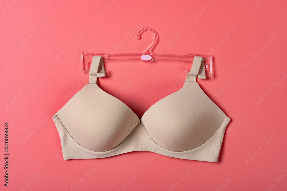 outside of a beige bra for women on a pink background outside of a beige bra for women on a pink background