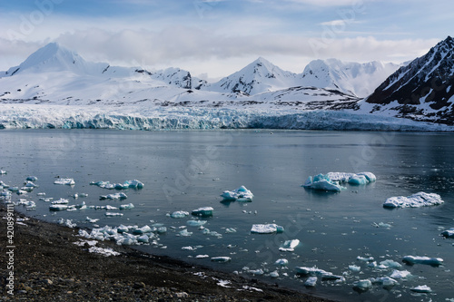 Coastal landscape with sea ice and snow covered mountains, Isbjornhamna, Hornsund bay, Spitsbergen, Svalbard, Norway photo