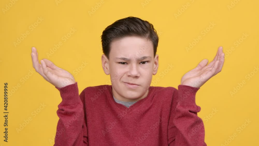 Teenager Boy Shrugging Shoulders Shaking Head In Disagreement, Yellow Background