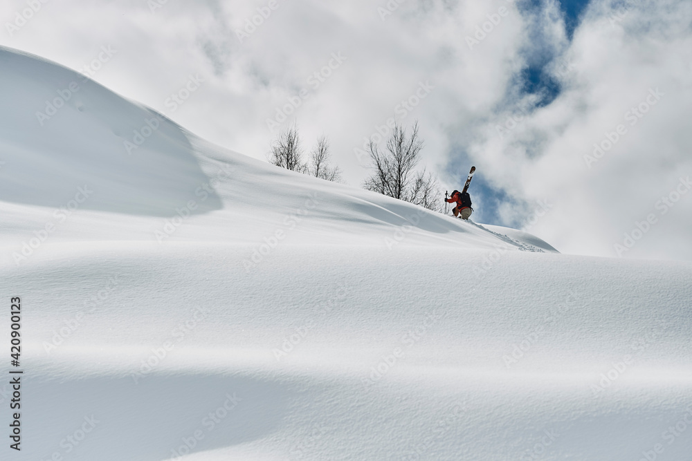 Male skier trudging up snow covered mountain, Alpe-d'Huez, Rhone-Alpes, France Male skier trudging up snow covered mountain, Alpe-d'Huez, Rhone-Alpes, France