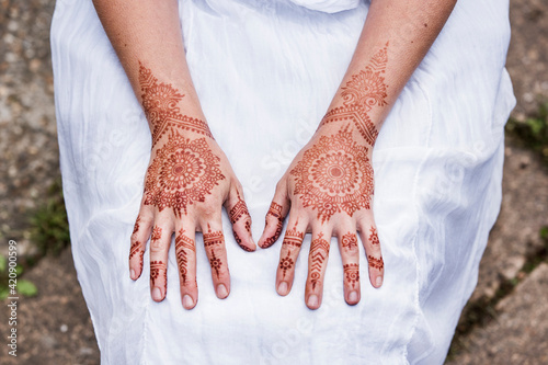 Woman in white dress with henna tattoo on hands