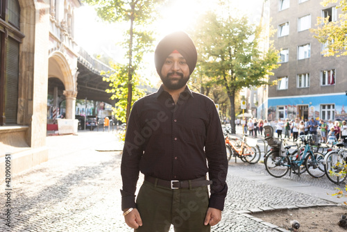 Indian man exploring city, bicycles in background, Berlin, Germany
