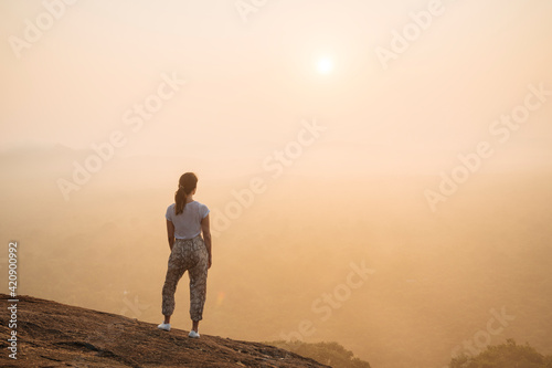 Woman watching sunrise from Pidurangala, Sigiriya, Central Province, Sri Lanka