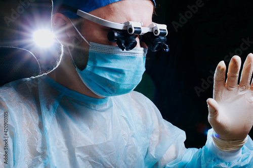 Fotografia neurosurgeon makes an operation in a medical clinic in glasses with close-up lenses