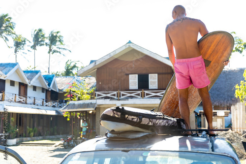 Man loading surfboards on top of vehicle, Pagudpud, Ilocos Norte, Philippines