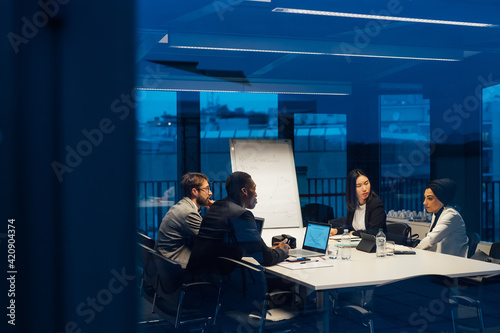 Businessmen and women having discussion during conference table meeting