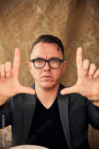 Comedian with camera hand gesture