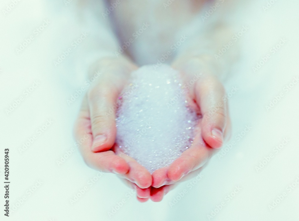 Fototapeta premium bath foam. baby hands in bubble bath, baby washing in bubble bath