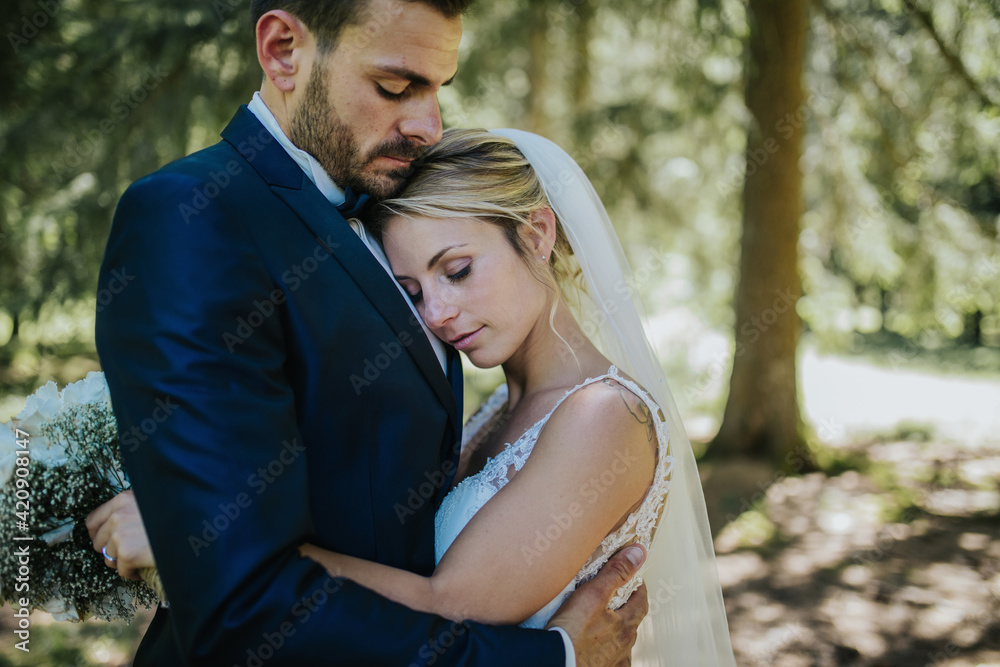 Romantic bride and groom hugging each other in woodland Romantic bride and groom hugging each other in woodland