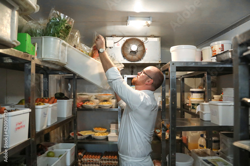 Chef checking stock of goods in storage room