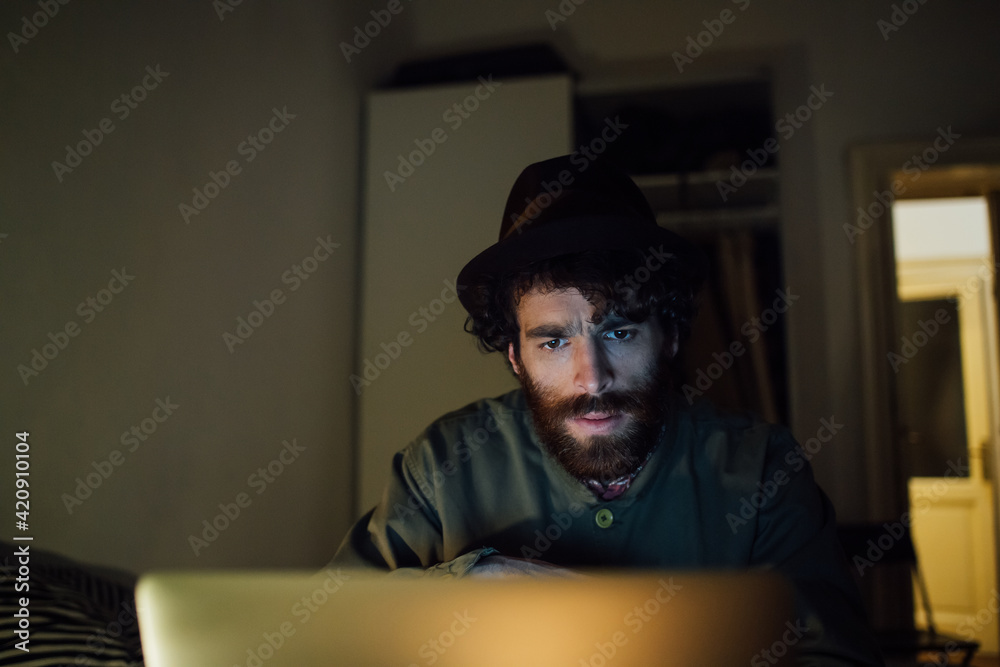 Bearded young man using laptop at home Bearded young man using laptop at home