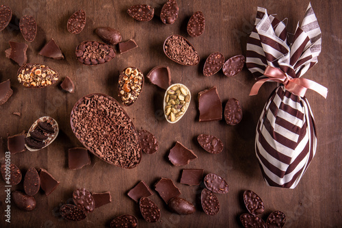 Canvas Print Top view of lots of mini stuffed chocolate easter eggs and cracked chocolates on a wooden table