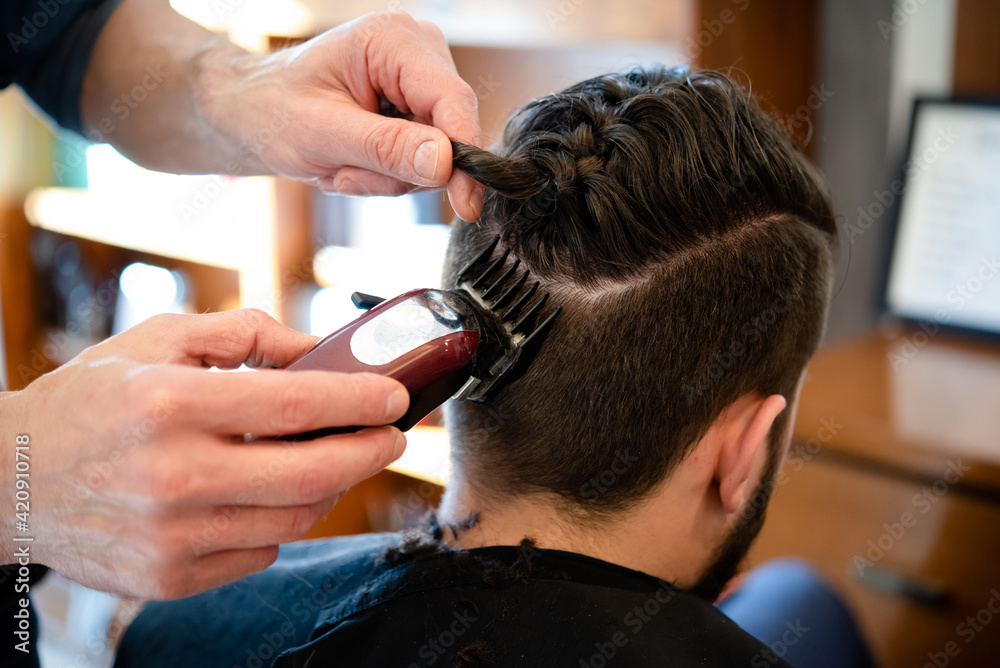 Hairdresser shaving customer's hair in barber shop Hairdresser shaving customer's hair in barber shop