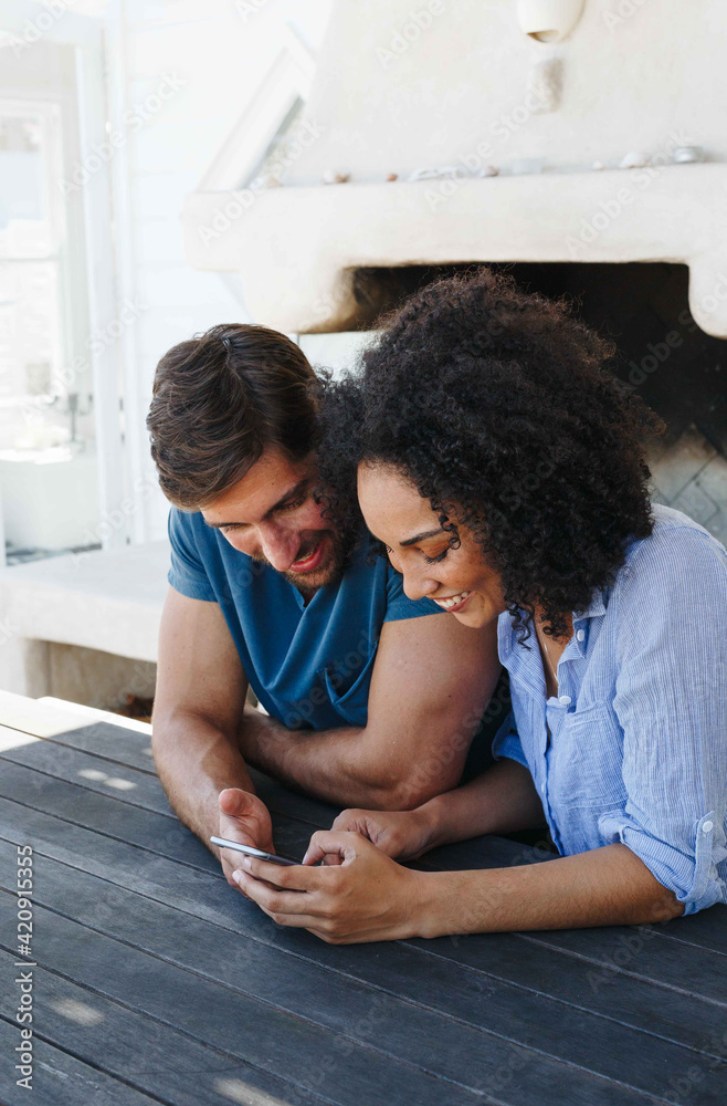 Couple using smartphone in beach house Couple using smartphone in beach house